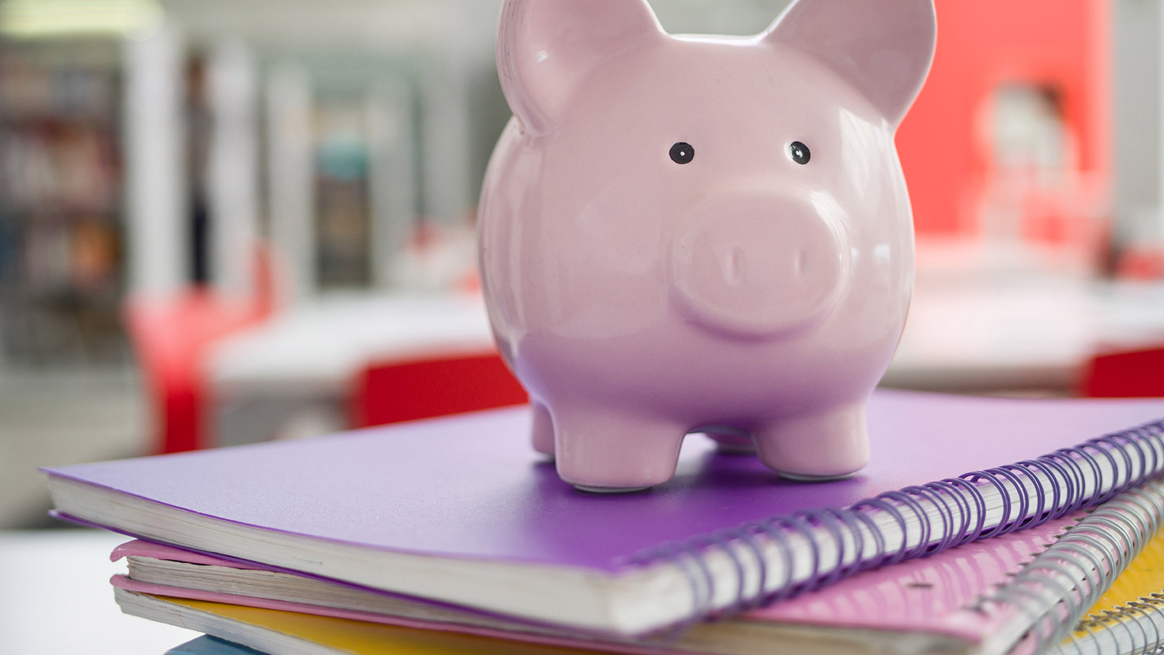 Sparschwein auf Studienbüchern