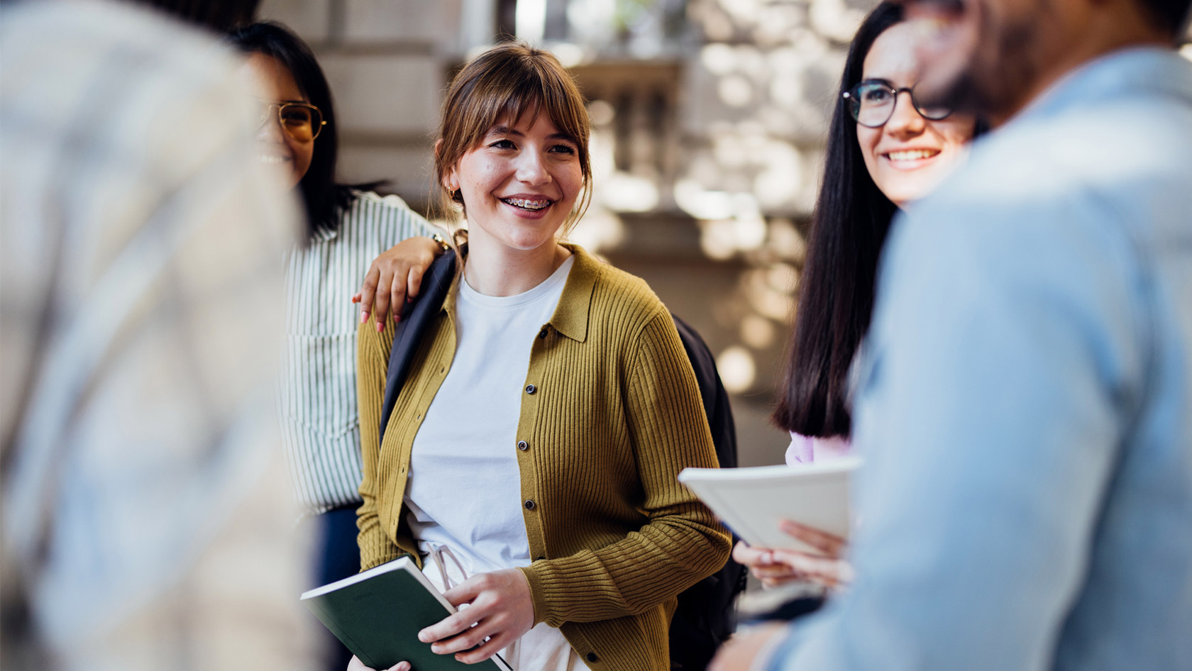 Eine Studentin im Gespräch mit vier anderen Studierenden